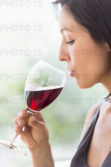 Woman tasting red wine.