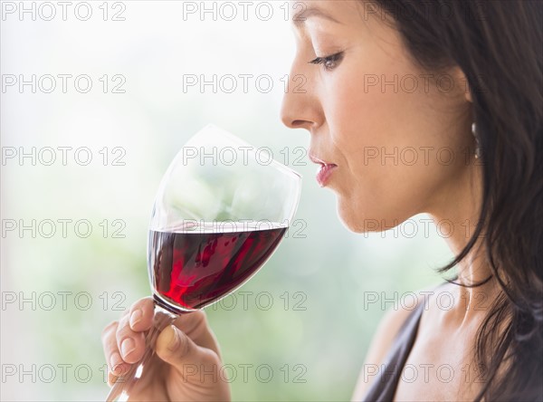 Woman tasting red wine.