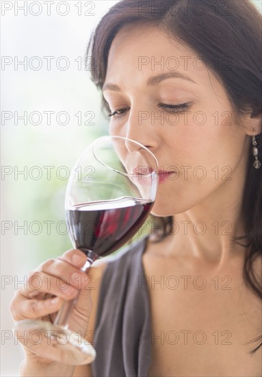 Woman tasting red wine.