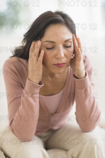 Woman sitting with head in hands.