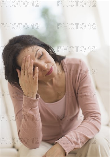 Woman sitting with head in hands.