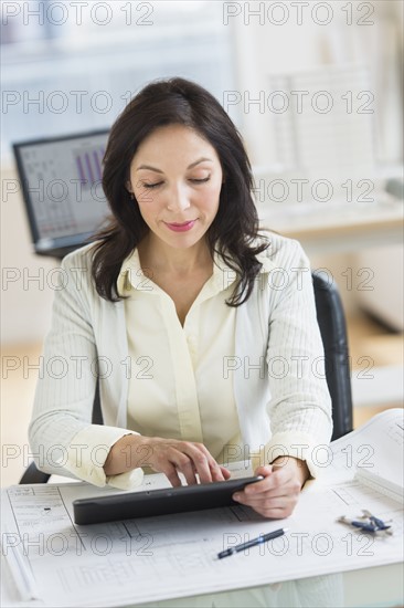 Architect working on digital tablet in office.