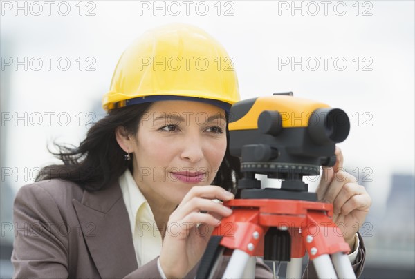 Architect looking through theodolite.