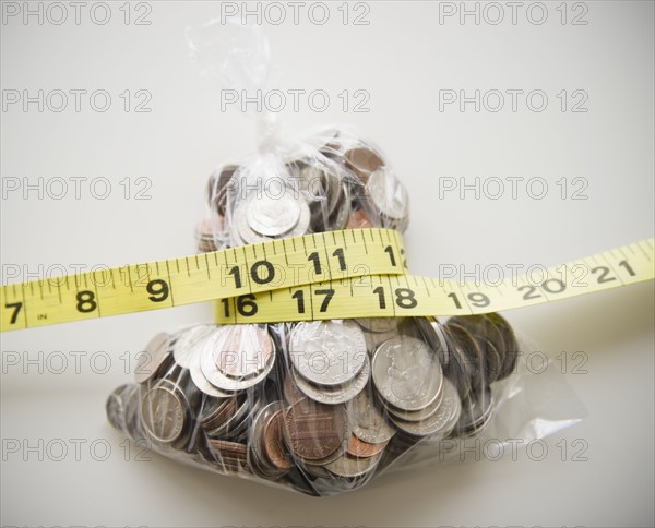 Savings in plastic bag tied up with tape measure. 
Photo : Jamie Grill