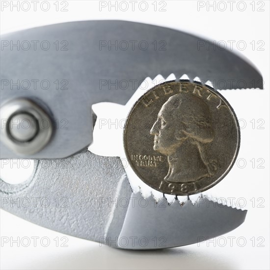 Wrench squeezing coin. 
Photo : Jamie Grill