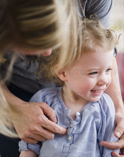 Mother tickling daughter (2-3). 
Photo : Jamie Grill