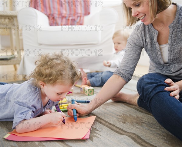 Mother playing with children (2-3, 6-11 months) at home. 
Photo : Jamie Grill