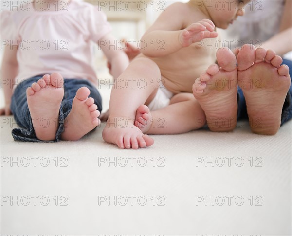 Feet of mother and children (6-11 months, 2-3). 
Photo: Jamie Grill