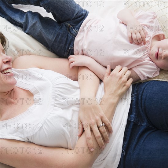 Mother and daughter (2-3) lying in bed. 
Photo : Jamie Grill