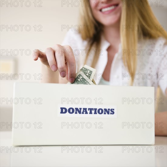Woman putting money into donation box. 
Photo: Jamie Grill