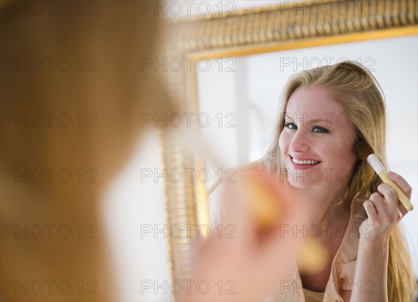 Woman applying blush. 
Photo : Jamie Grill