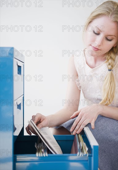 Woman looking into file cabinet. 
Photo : Jamie Grill