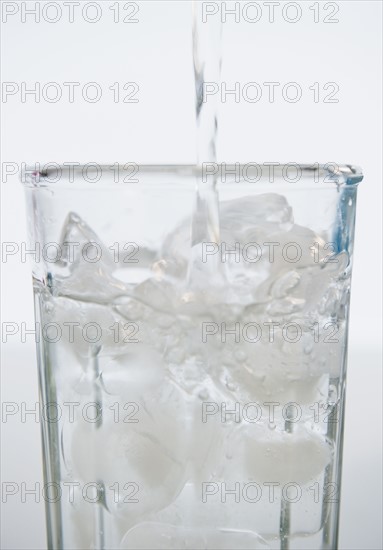 Water being poured into glass with ice cubes. 
Photo : Jamie Grill
