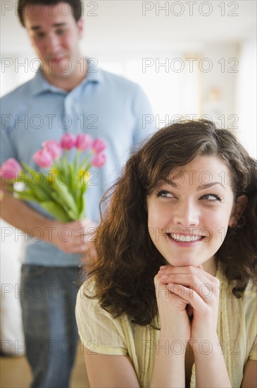 Woman smiling, man with flowers in background.
Photo : Jamie Grill
