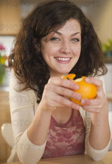 Woman peeling orange. 
Photo : Jamie Grill