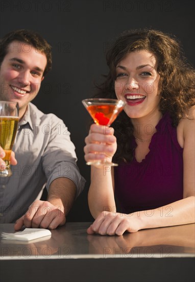 Couple sitting at bar counter and enjoying drinks. 
Photo : Jamie Grill