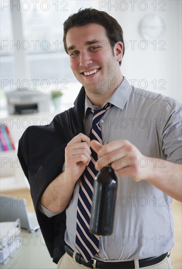 Business man leaving office with beer bottle. 
Photo : Jamie Grill