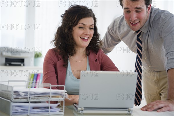 Business woman and business man working on laptop. 
Photo : Jamie Grill