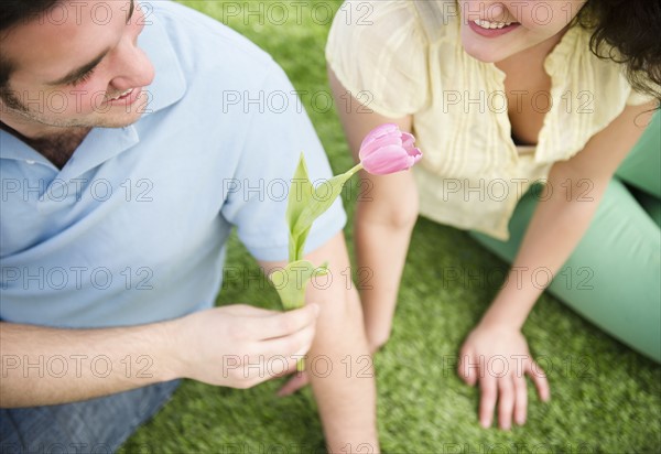 Couple sitting on grass. 
Photo : Jamie Grill