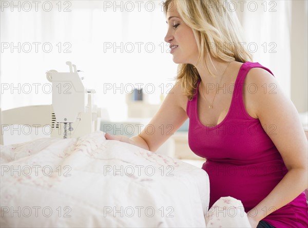 Pregnant woman sewing baby blanket. 
Photo : Jamie Grill