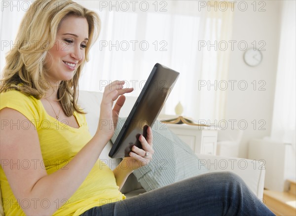 Pregnant woman using digital tablet. 
Photo : Jamie Grill