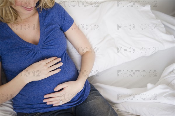 Pregnant woman sitting in bed. 
Photo : Jamie Grill