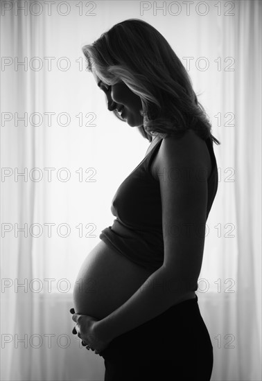 Pregnant woman standing by window. 
Photo : Jamie Grill