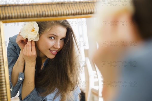 Woman adjusting flower in hair. 
Photo : Jamie Grill