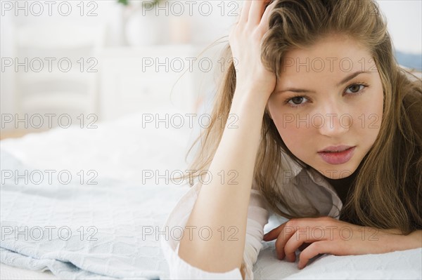 Portrait of woman lying on bed. 
Photo : Jamie Grill