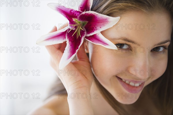 Portrait of woman with tropical flower in hair. 
Photo: Jamie Grill