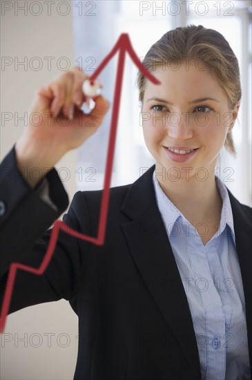 Woman drawing graph on glass . 
Photo : Jamie Grill