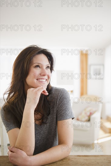 Woman sitting at table and smiling. 
Photo : Jamie Grill