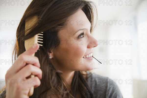 Woman brushing hair. 
Photo : Jamie Grill