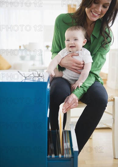 Mother with baby daughter (6-11 months) working in home office. 
Photo : Jamie Grill