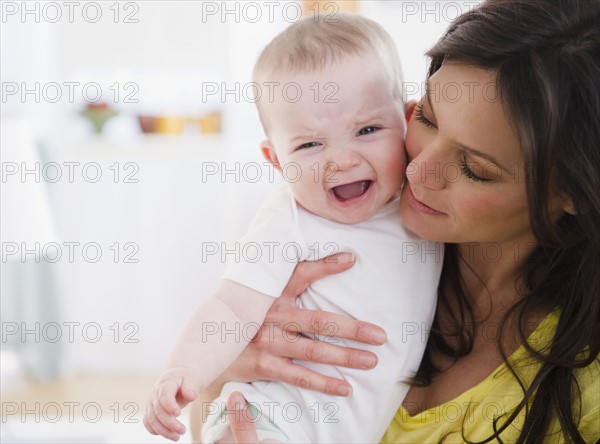 Mother consoling baby daughter (6-11 months). 
Photo : Jamie Grill