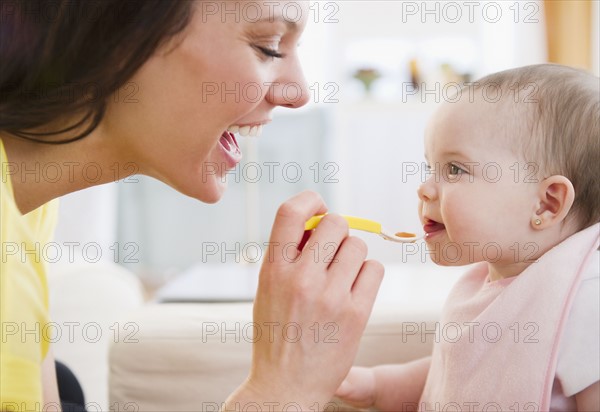 Mother feeding baby daughter (6-11 months). 
Photo : Jamie Grill