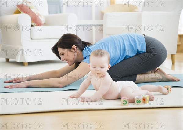 Mother with baby daughter (6-11 months) practicing yoga. 
Photo : Jamie Grill