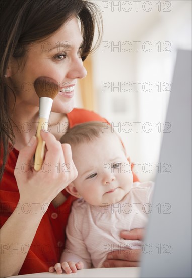 Mother with baby daughter (6-11 months) doing make up. 
Photo: Jamie Grill