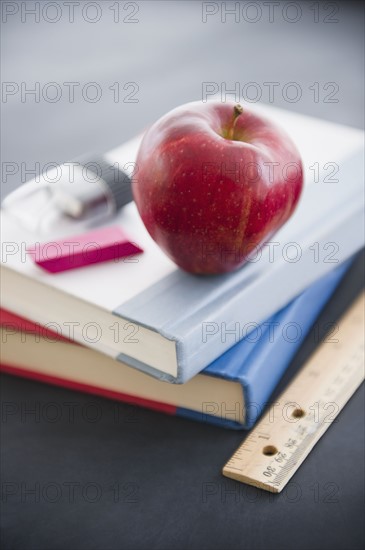 Close up apple lying on book. 
Photo : Jamie Grill