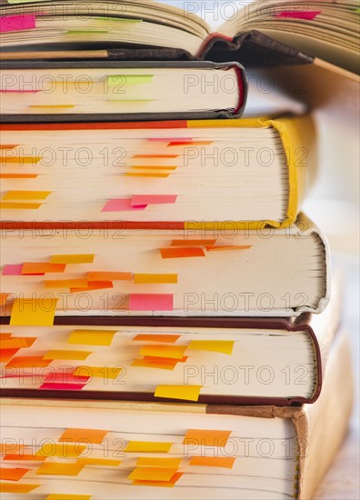Close up adhesive notes in books, studio shot. 
Photo: Daniel Grill