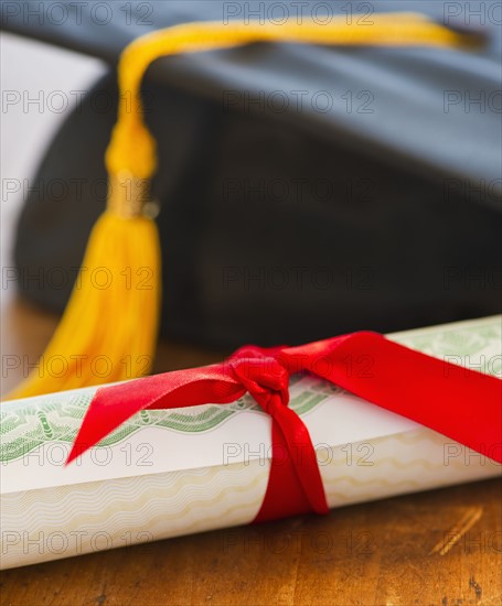 Close up of diploma and mortarboard, studio shot. 
Photo : Daniel Grill