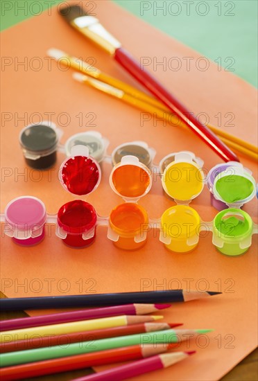 Close up of watercolor paints, crayons and paintbrushes, studio shot. 
Photo : Daniel Grill