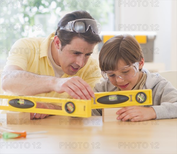 Father and son (10-11 years) using levels. 
Photo : Daniel Grill