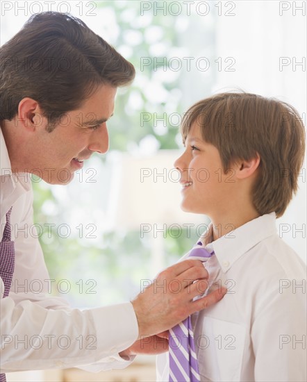 Father helping son (10-11 years) to tie tie. 
Photo : Daniel Grill