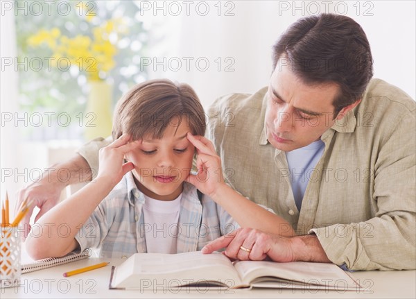 Father helping son (10-11 years) with his homework. 
Photo: Daniel Grill