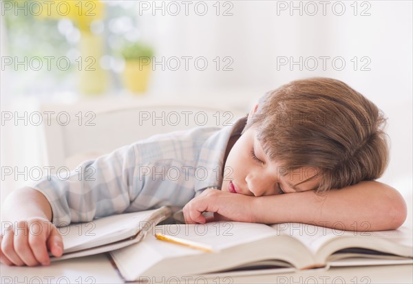 Boy (10-11 years) sleeping on books while doing homework. 
Photo: Daniel Grill