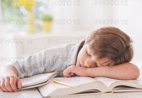 Boy (10-11 years) sleeping on books while doing homework.
Photo : Daniel Grill