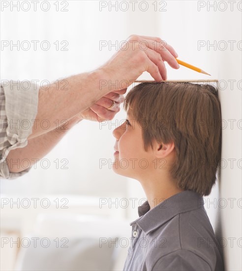 Father measuring son's (10-11 years) height. 
Photo: Daniel Grill