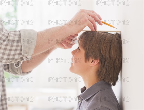 Father measuring son's (10-11 years) height. 
Photo: Daniel Grill