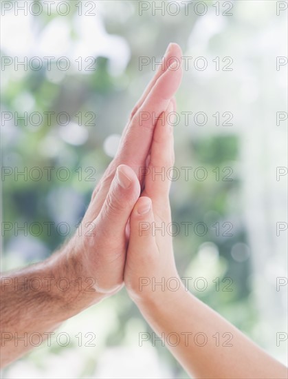 Close up of father's and son's (10-11 years) hands doing high five.
Photo : Daniel Grill